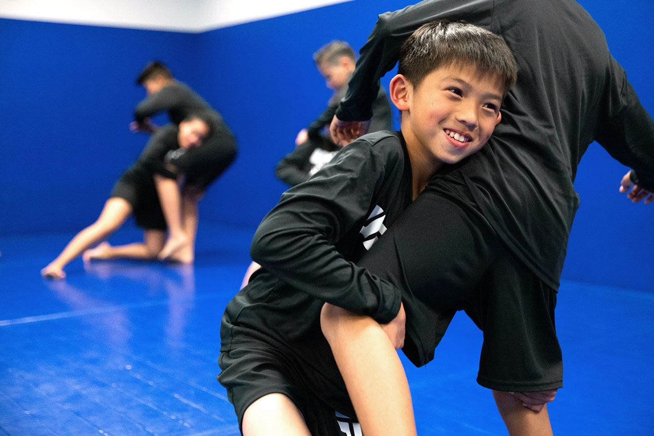 Young members practicing brazilian jiu jitsu